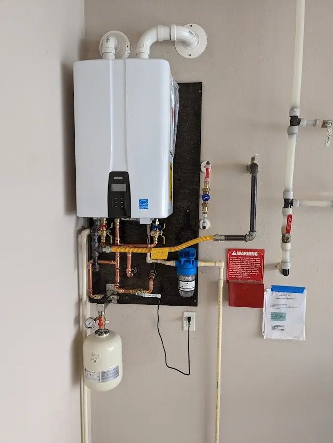 Professional plumber installing copper piping in a Litchfield home